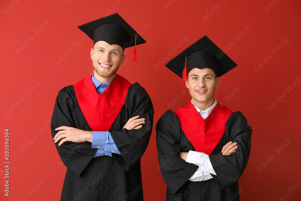 彩色背景下穿着学士长袍的年轻学生