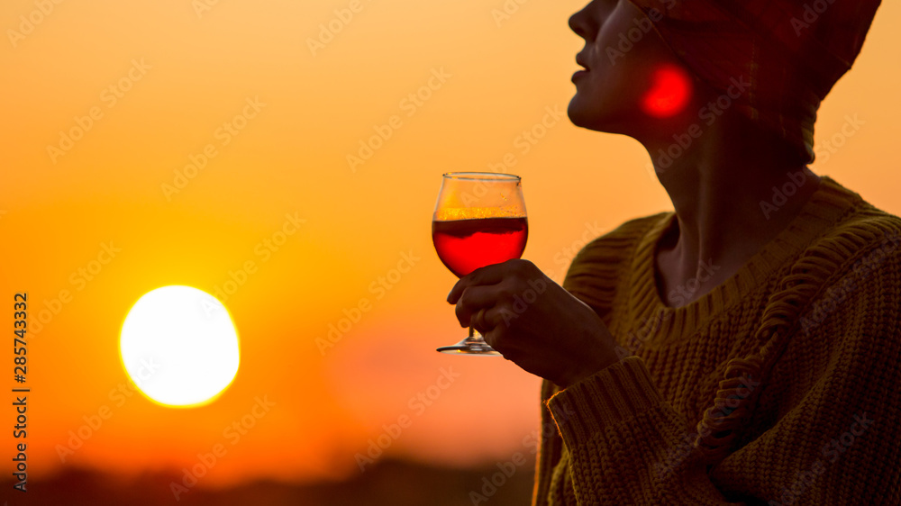 美丽的秋天女人喝着橙色的aperol（红酒）杯看日落-奢华的生活方式b