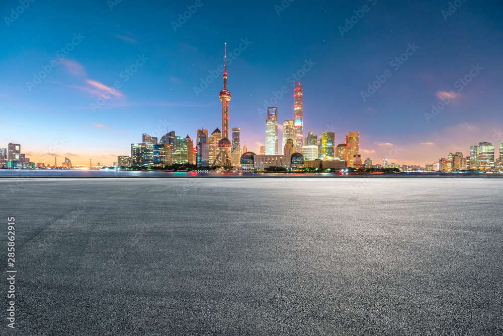 中国上海，空旷的赛道和夜晚的现代城市风光。