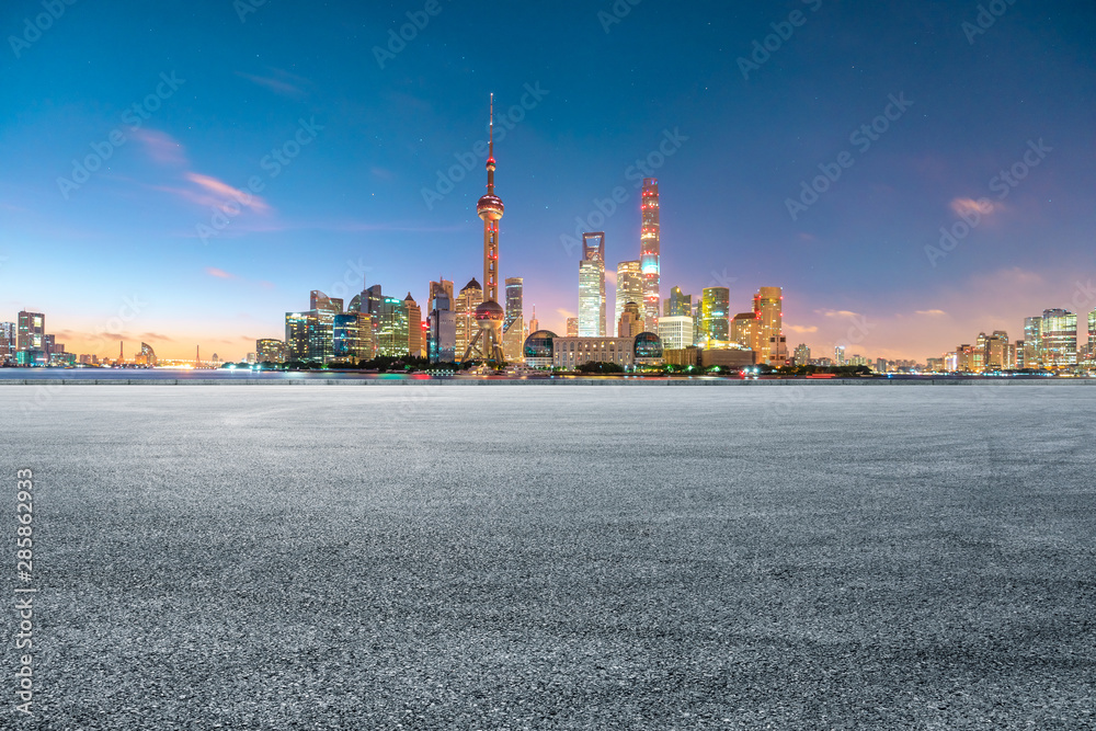 中国上海，空旷的赛道和夜晚的现代城市风光。