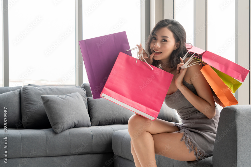 快乐女士拿着购物袋，喜欢在百货商店的零售店买东西。生活方式