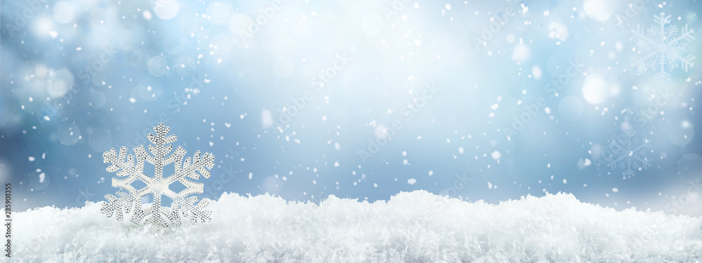 带有雪堆的节日冬季雪背景，带有美丽光线的银色装饰雪花和