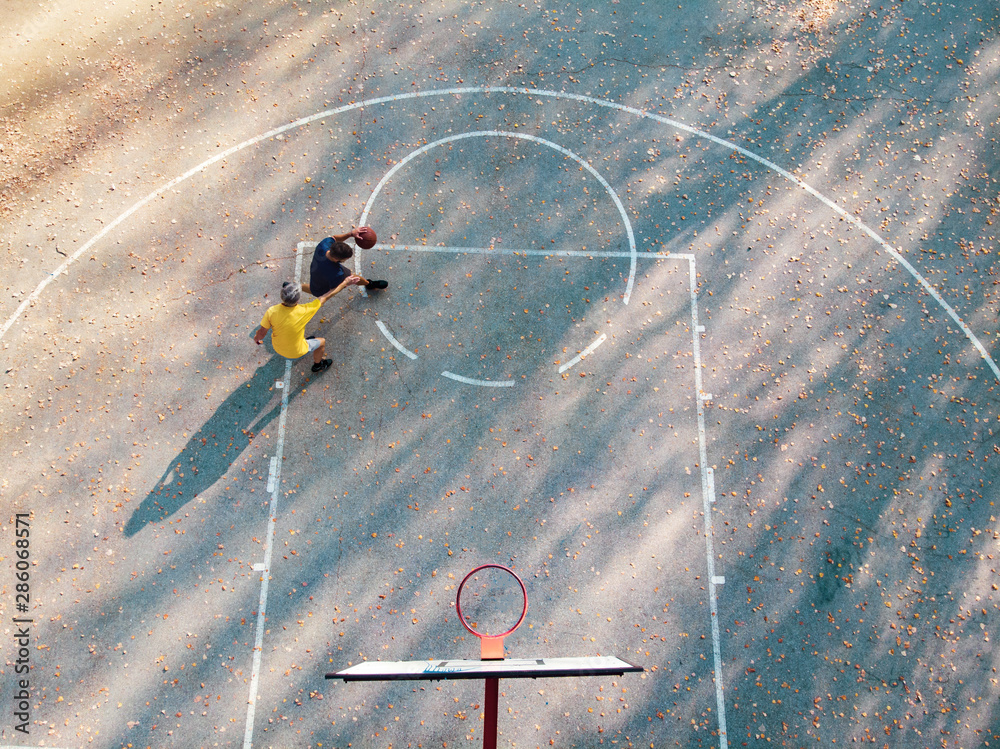 父亲和儿子在公园里打篮球