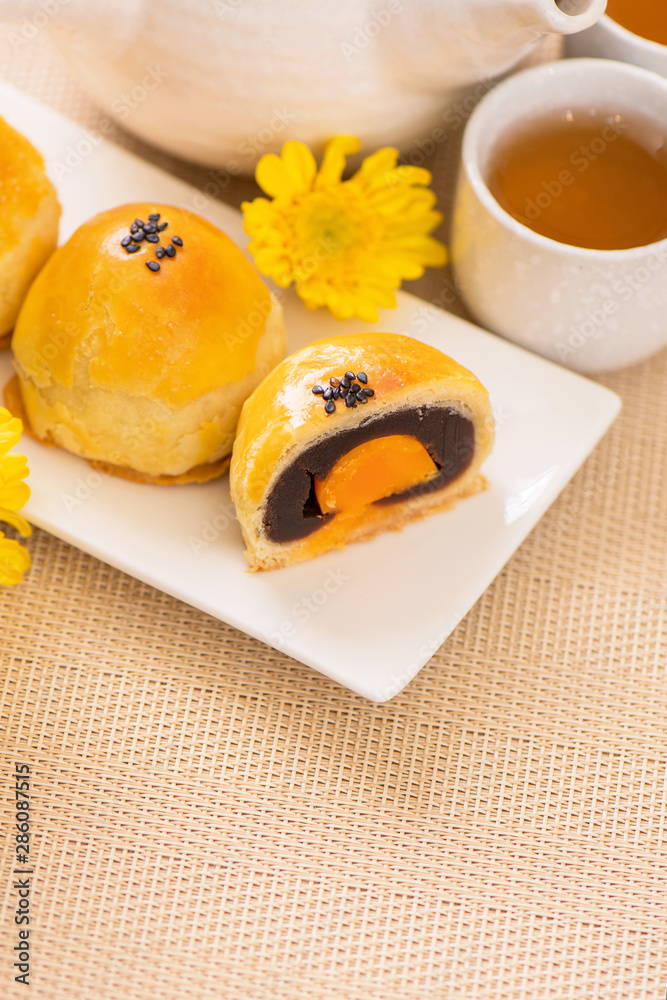 在明亮的木桌背景上为中秋节准备的美味烤蛋黄酥月饼。Chi