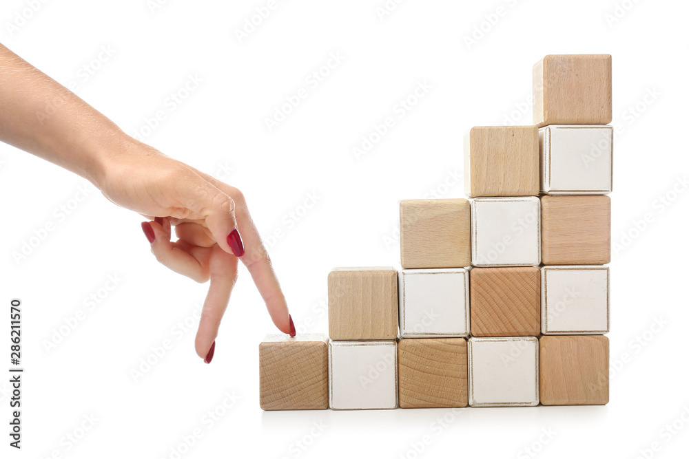 白色背景下堆叠的立方体和模仿上楼的女性手。进步的概念