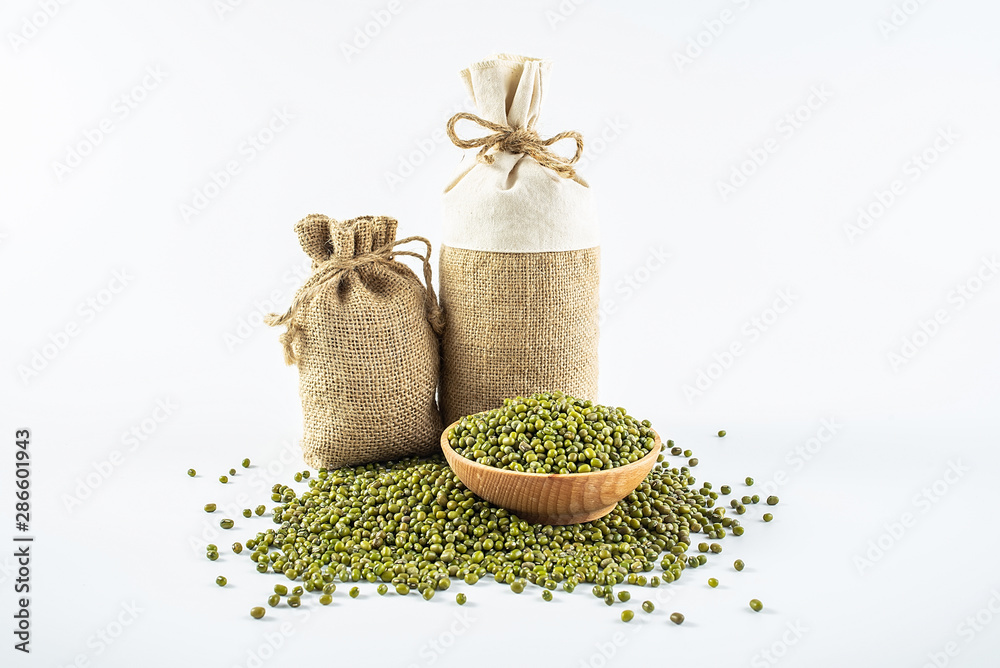 Sacks filled with grain and a bowl of mung beans on a white background