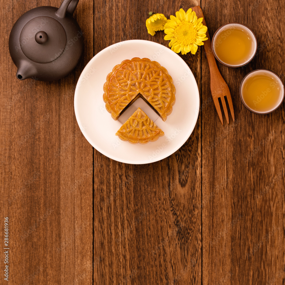 深色木桌上的月饼配茶，中秋节传统美食的节日理念la