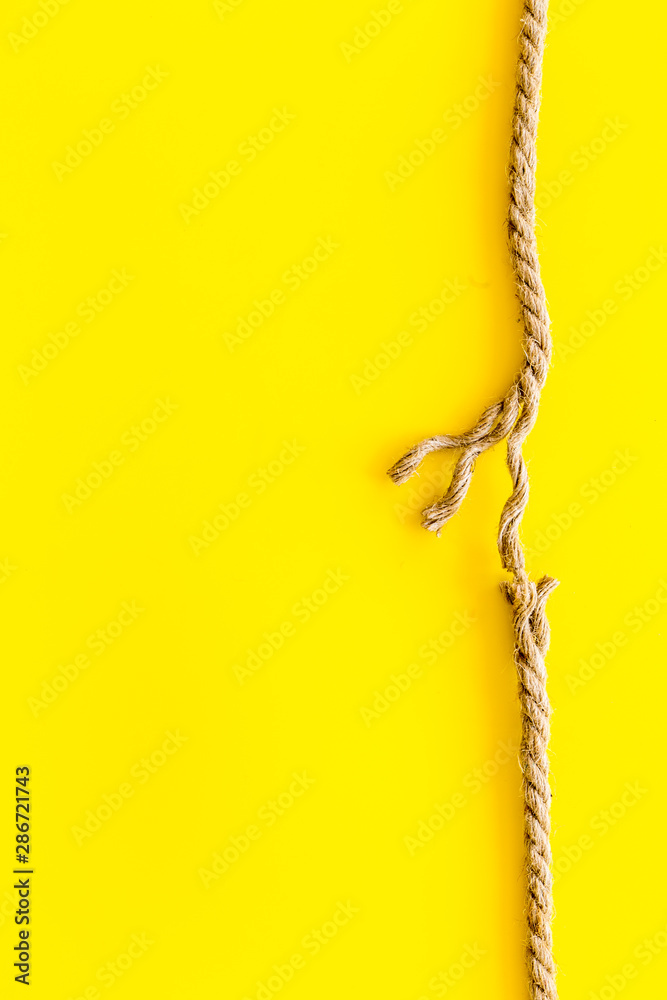 黄色背景上绳索接近断裂的风险概念，文本俯视图空间