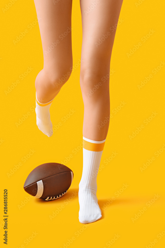 穿着袜子、背景是橄榄球的年轻女子的腿