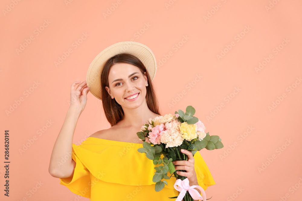 美丽的年轻女子，彩色背景上有一束康乃馨花