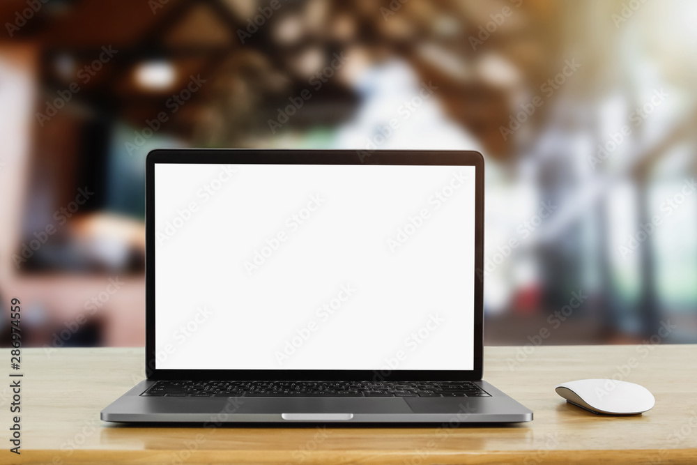 咖啡馆背景中桌上的笔记本电脑空白白色屏幕