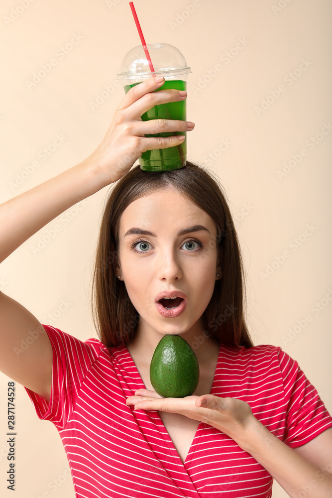 情绪激动的女人，在浅色背景下喝健康的蔬菜汁和鳄梨