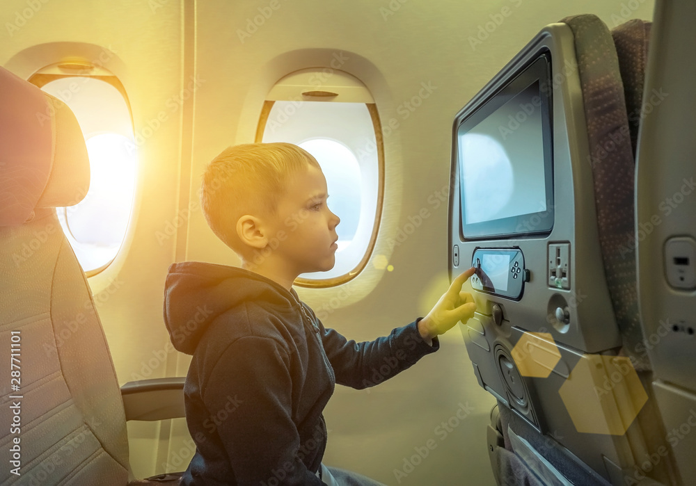可爱的小男孩坐飞机旅行。孩子坐在飞机旁