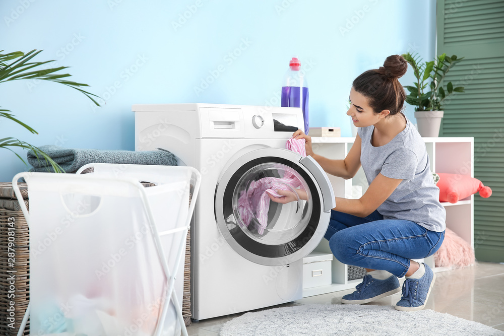 漂亮的年轻女人在家洗衣服