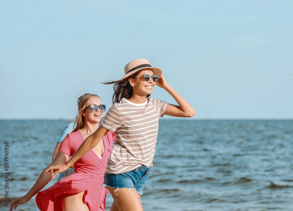 快乐的朋友们在度假胜地的沙滩上跑步