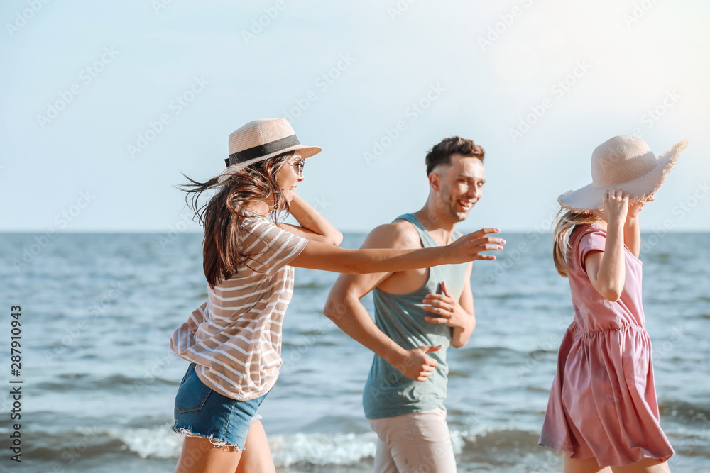 快乐的朋友在度假胜地的海滩上跑步