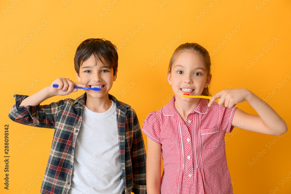 可爱的小孩在彩色背景下清洁牙齿