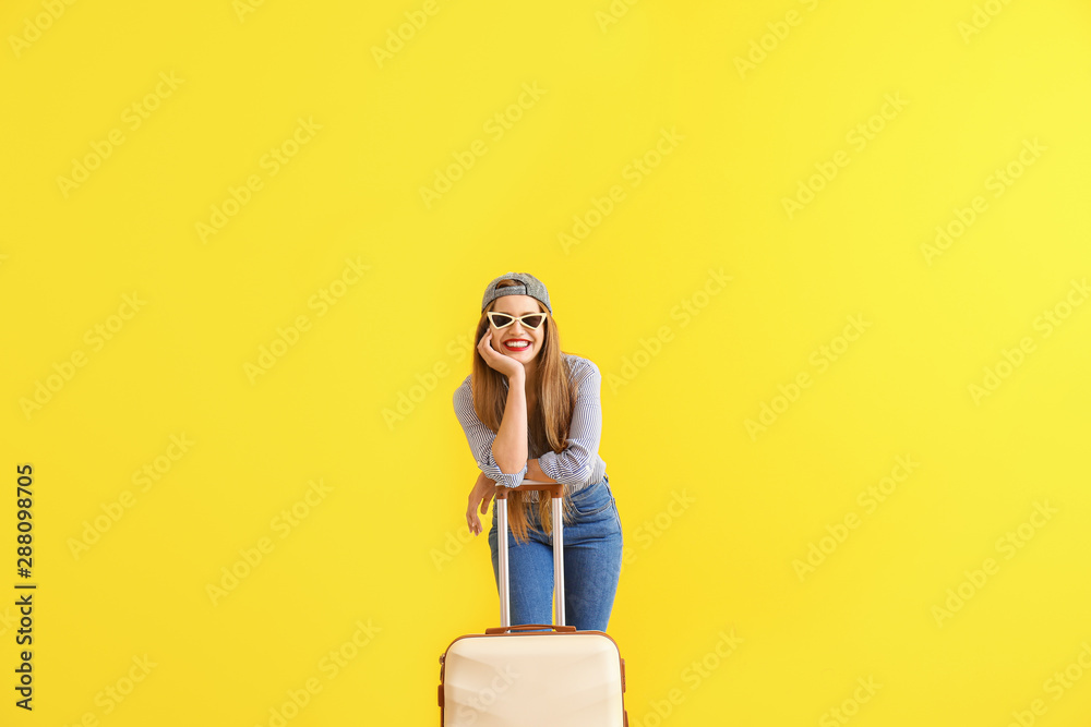 快乐的年轻女人，带着彩色背景的行李箱