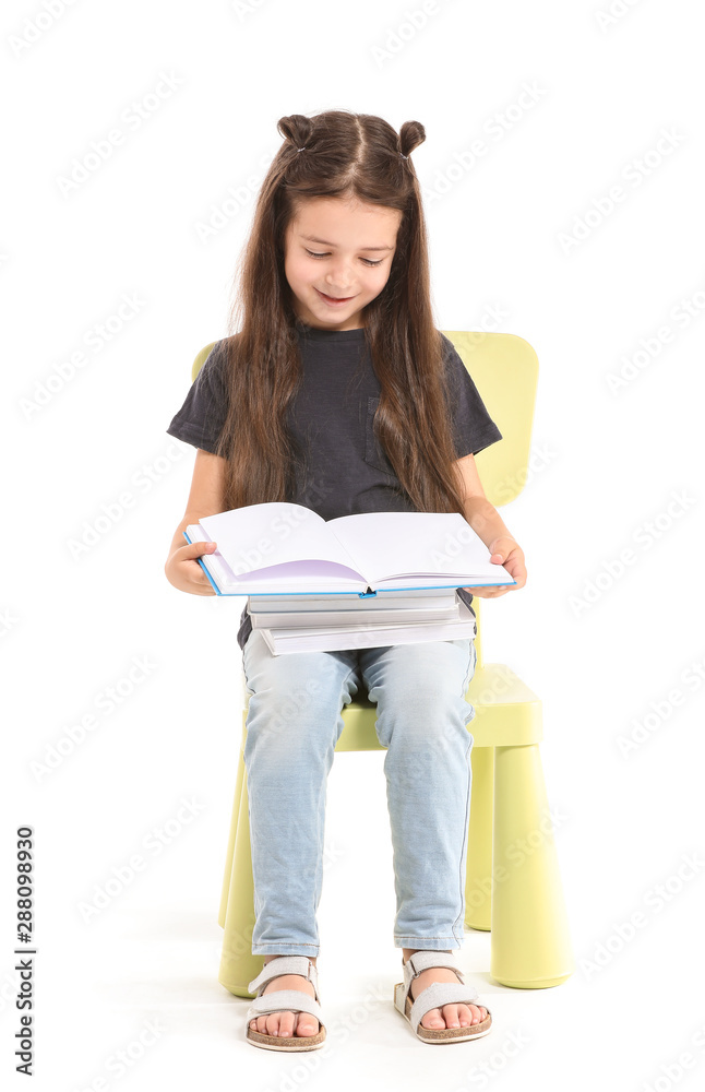 白色背景下坐在椅子上看书的可爱小女孩