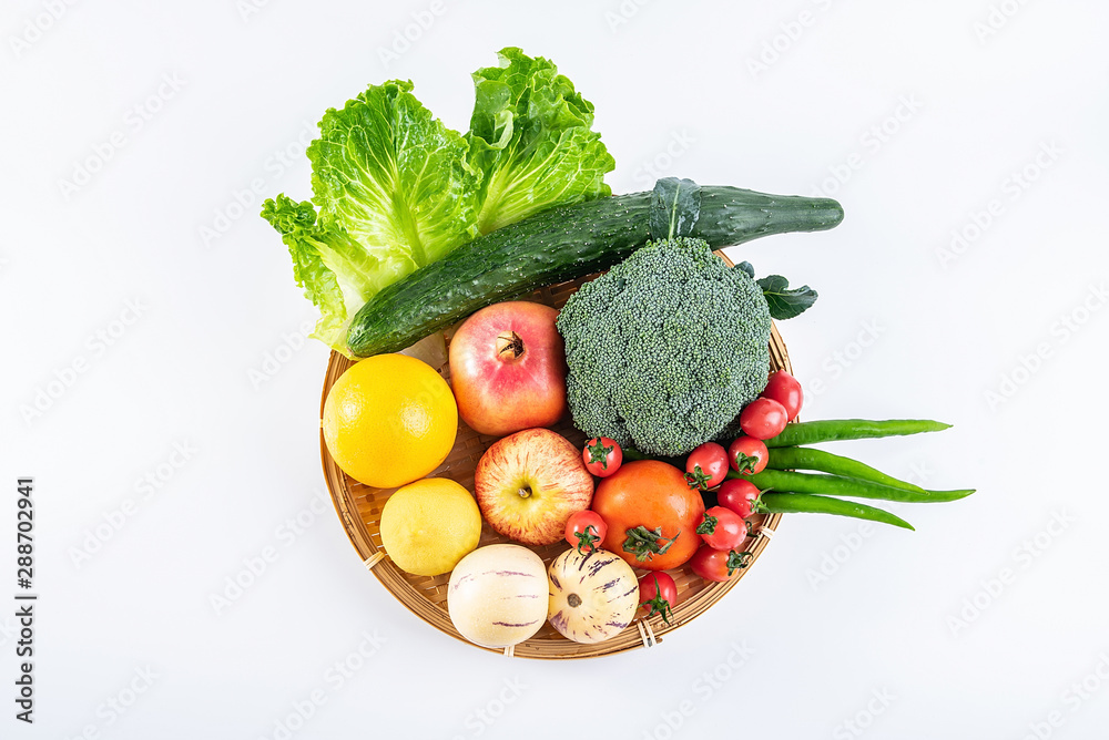 一个竹盘子，里面装着新鲜的时令蔬菜和水果，白底