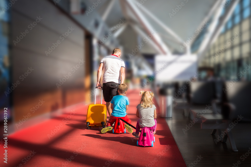 父亲带着两个孩子在机场航站楼一起度假