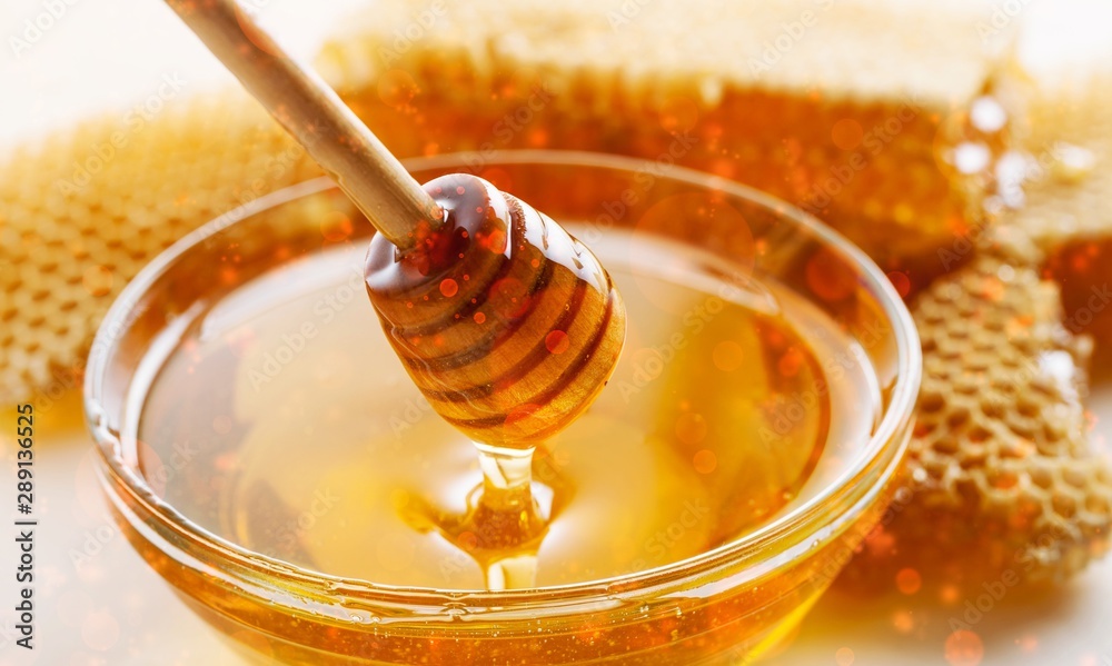 光滑背景下的玻璃碗中的蜂蜜