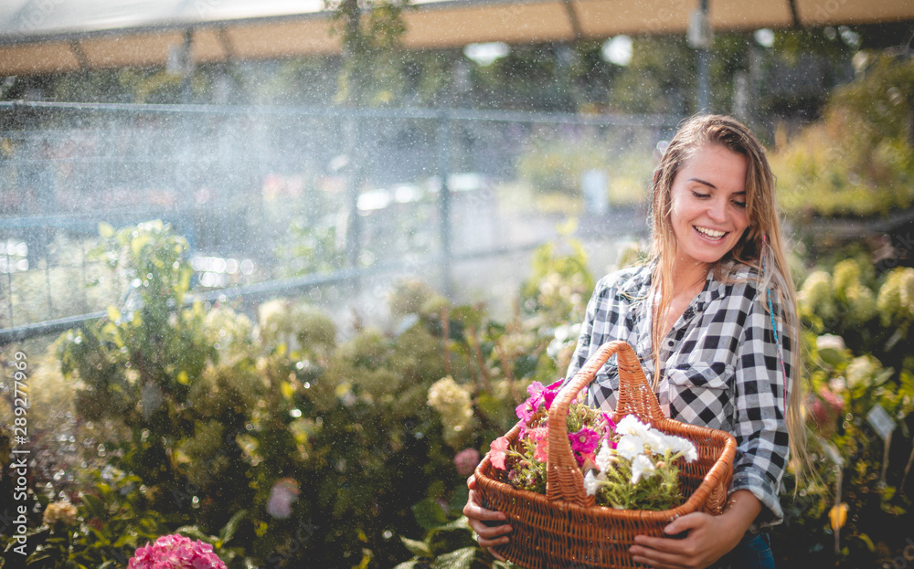 Smiling customer walking along path in garden center between rows of plants