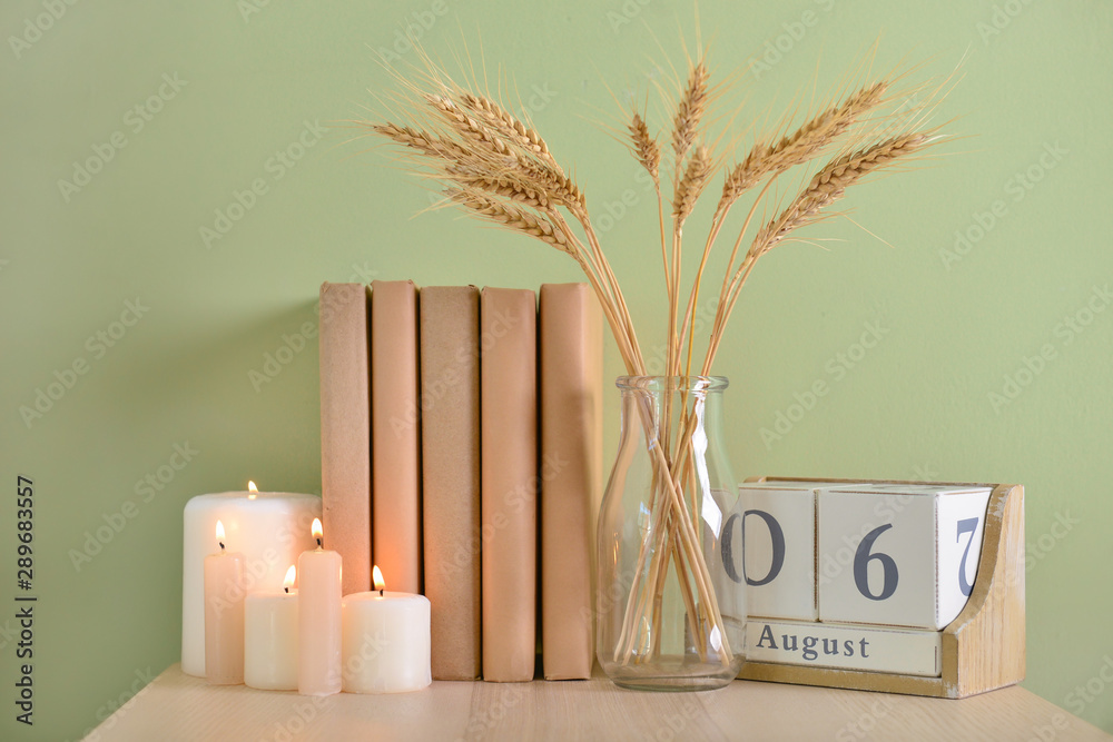 美丽的蜡烛，桌子上有书、日历和小麦小穗