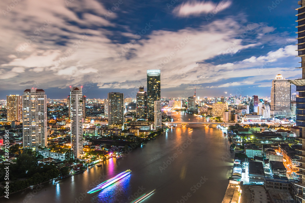 Bangkok cityscape rooftop view at night over Chao Phraya River waterfront with hotel buildings in ce