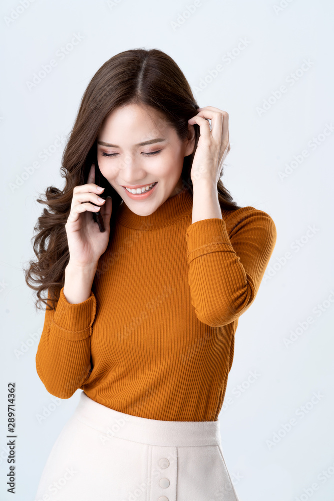 肖像美女亚洲女人棕色连衣裙微笑着快乐自信快乐的手持智能手机b
