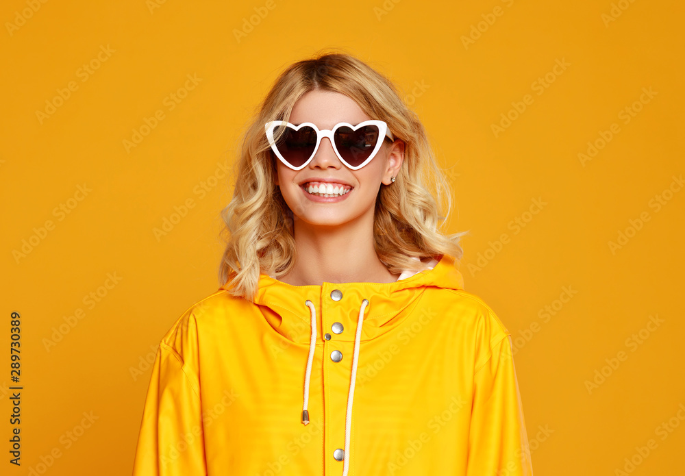 快乐的情绪女孩，戴着秋天黄色背景的太阳镜。