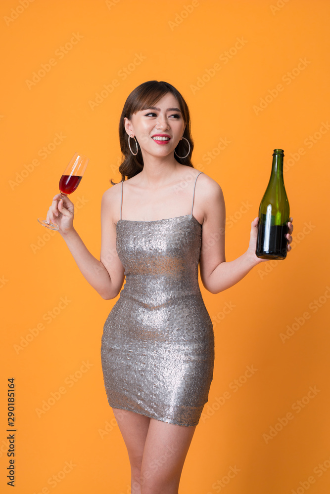 华丽的节日亚洲年轻女子正在喝一杯葡萄酒。