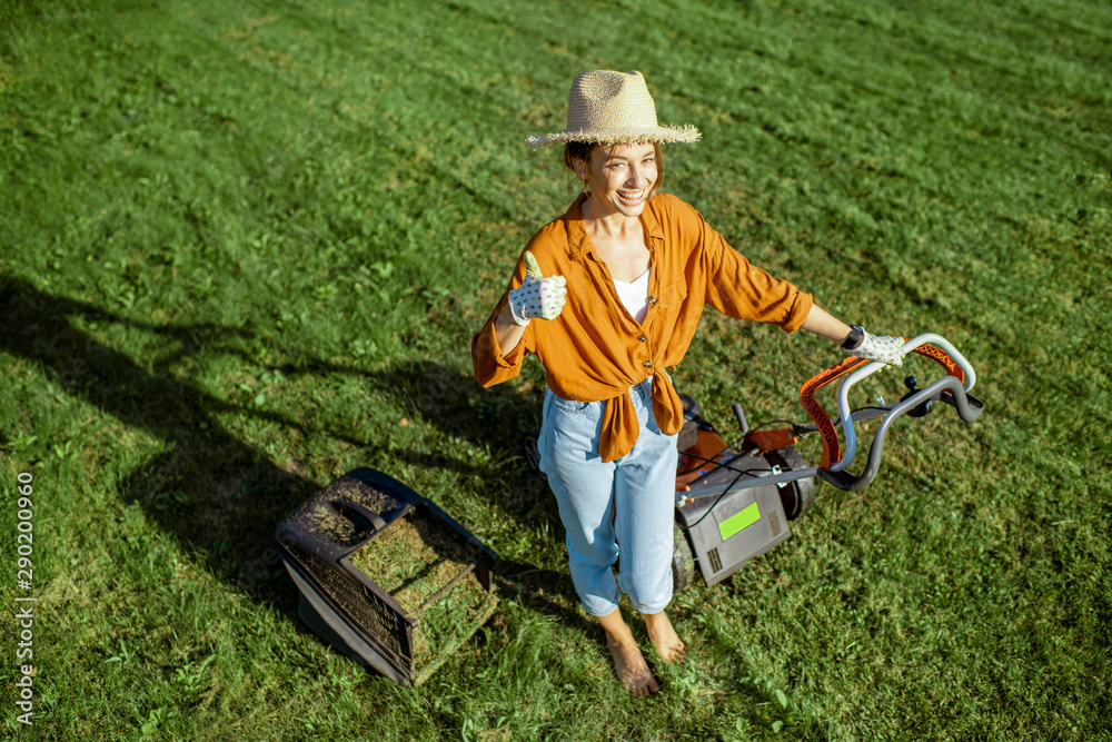 一位穿着休闲的年轻美女的画像，她开着割草机割草