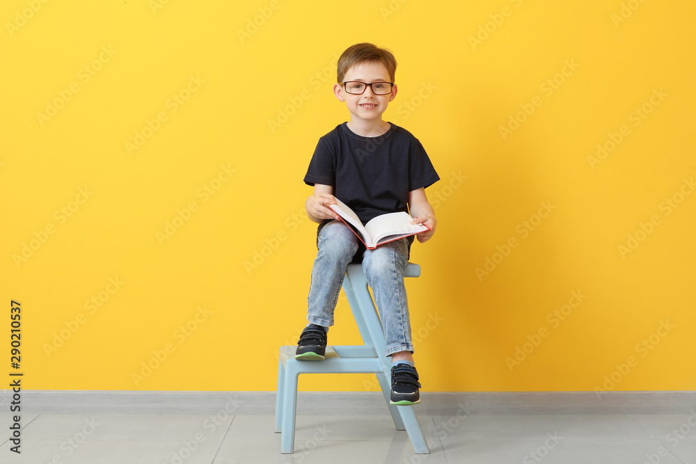 小男孩在彩色墙附近看书