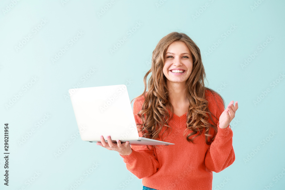 彩色背景下带笔记本电脑的快乐年轻女性肖像