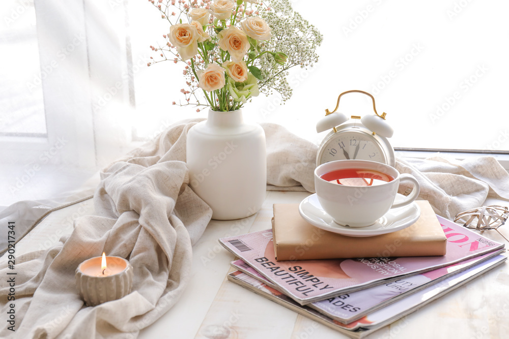 一杯热茶，窗台上放着书和杂志