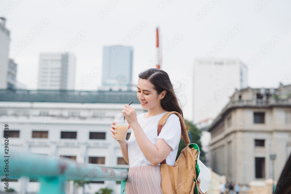 迷人时尚的可爱女孩在户外喝咖啡。