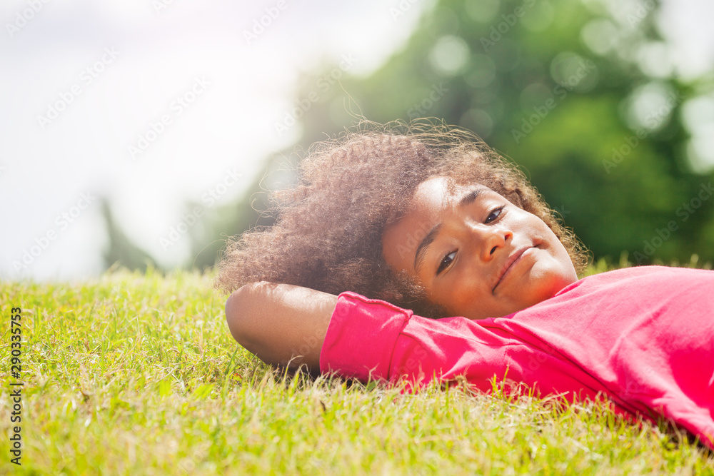 一个小女孩在公园草坪上休息的肖像
