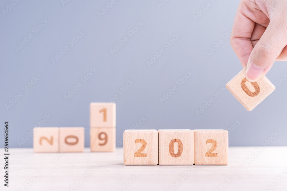 Abstract 2020 & 2019 New year countdown design concept - woman holding wood blocks cubes on wooden t