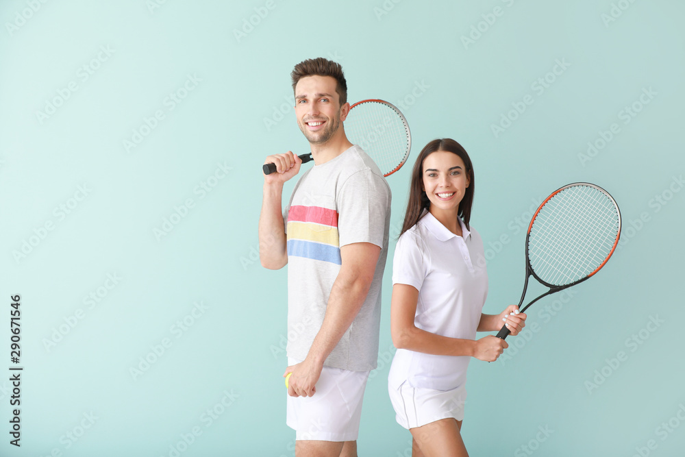 彩色背景上有网球拍的年轻情侣