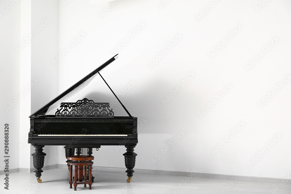 空房间白墙附近的黑色三角钢琴
