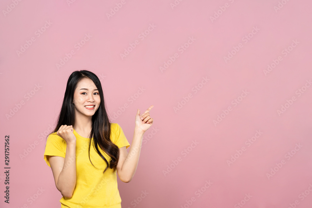 亚洲年轻美女微笑着用手指指着左上侧的一只手的肖像