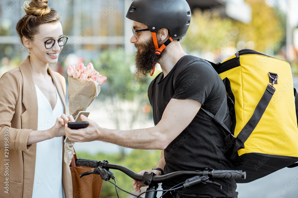 快递员骑自行车，背着快递背包，给一位年轻的商务女性送鲜花。F