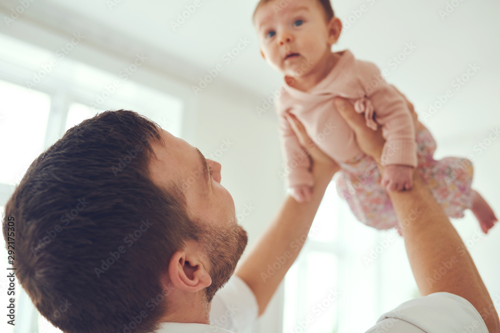 可爱的女婴被父亲抱到高空