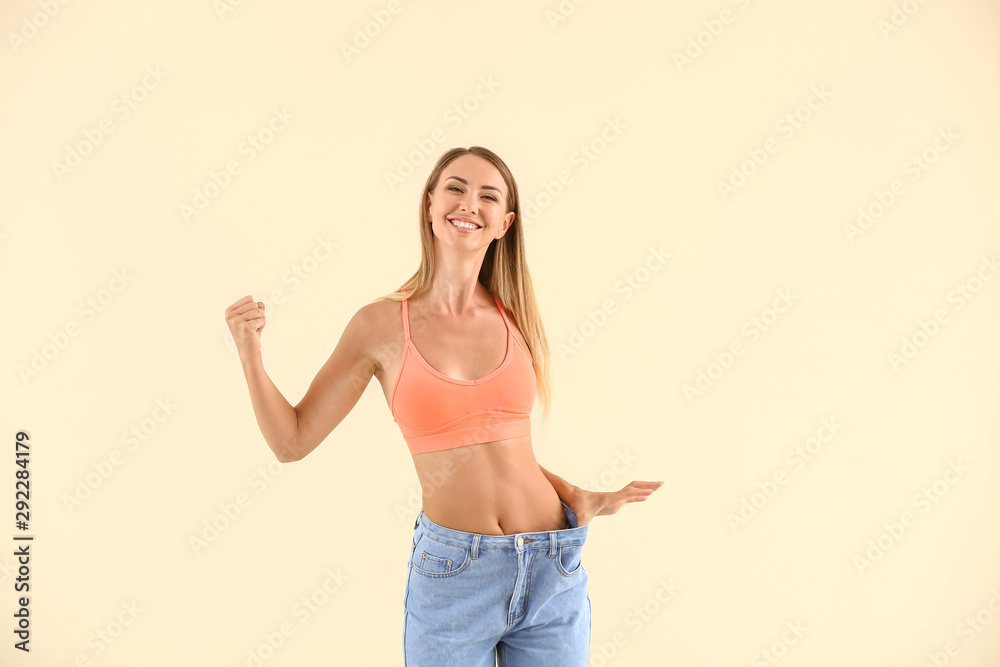 快乐的年轻女人，穿着宽松的彩色牛仔裤。减肥概念