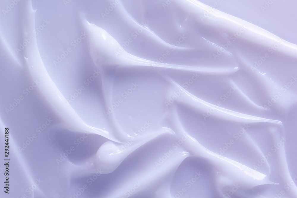 化妆品乳液背景。涂抹浅紫色奶油。保湿霜、面膜、奶油护肤品