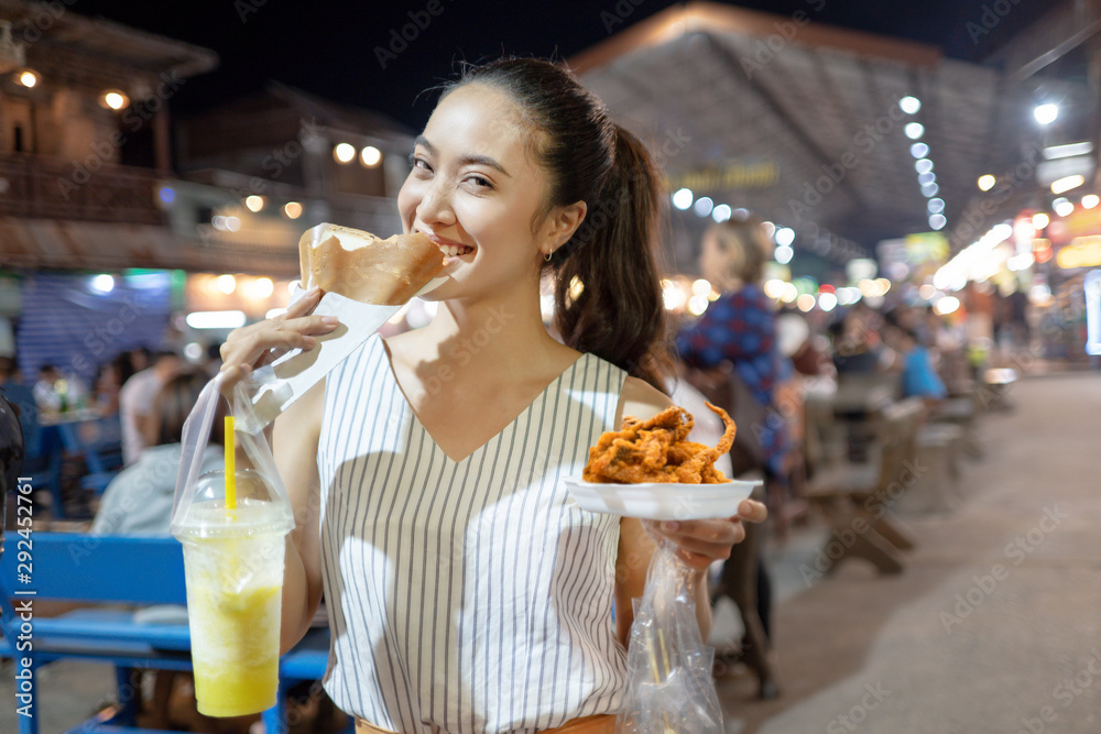亚洲人正在吃泰国街头美食晚餐。街头用餐。