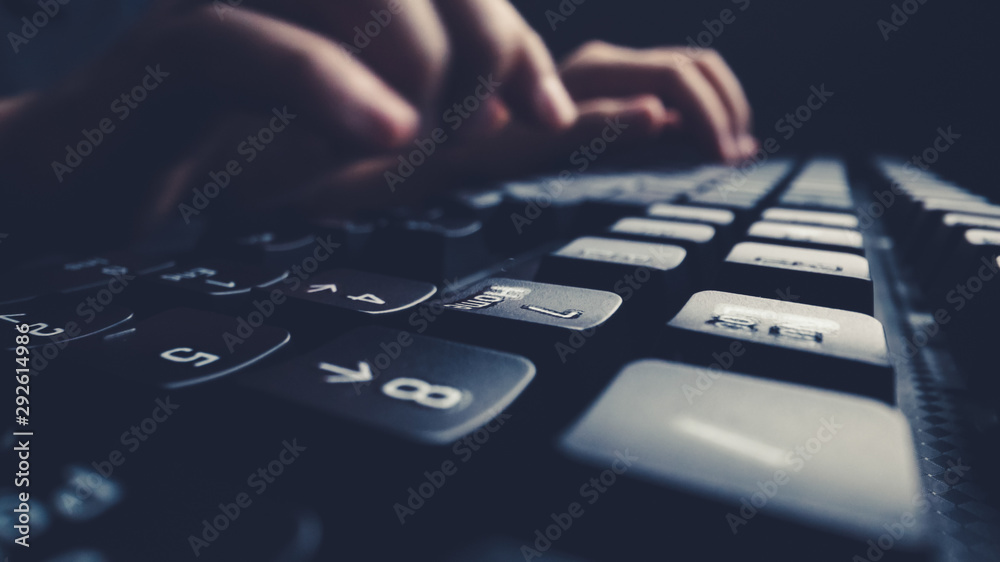 近距离柔焦手指在键盘上打字。在办公室里用笔记本电脑手动。编程