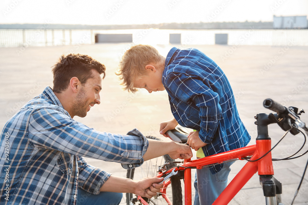 父亲和儿子在户外修理自行车