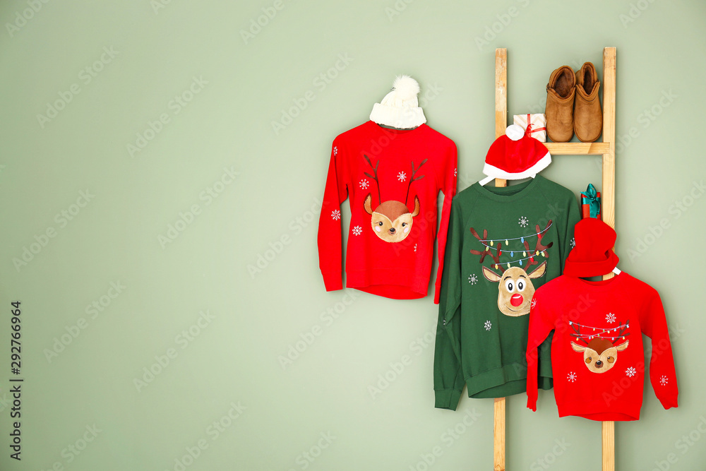 Set of family Christmas clothes on color background